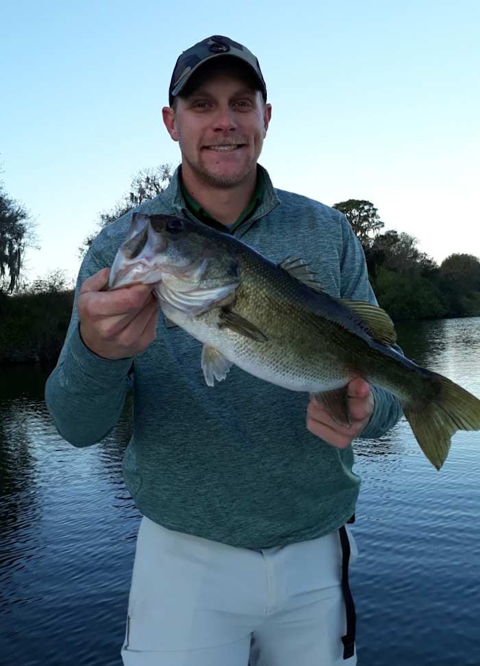 Streamsong Resort recreation coordinator and fishing guide Trey Talley displays one of the resort lake's catch-and-release bass.